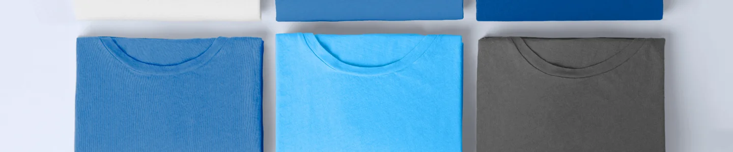 Chemises Gildan bleues et grises pliées sur fond blanc.