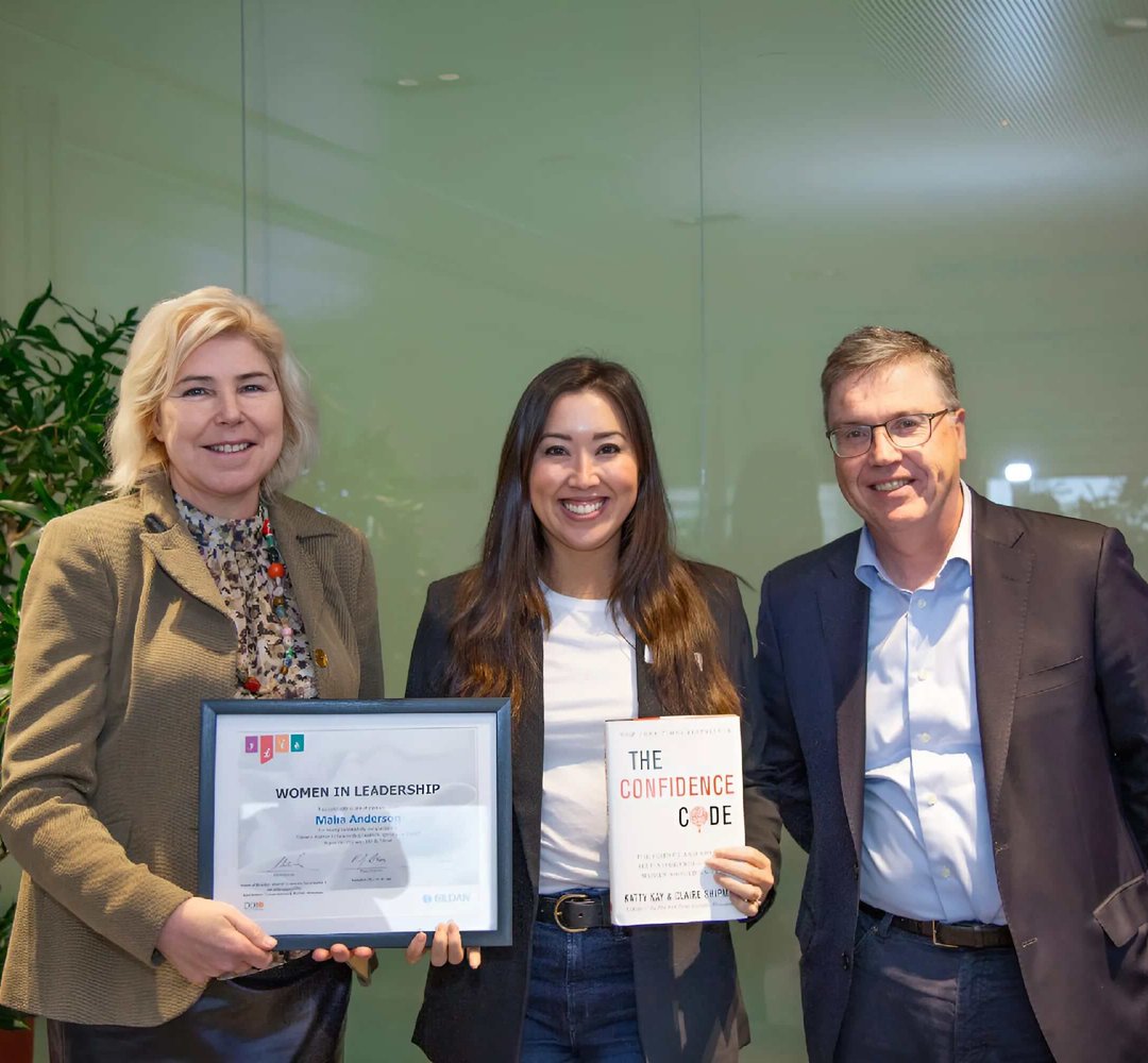 Une employée tient son diplôme après avoir suivi le programme Women in Leadership de Gildan.