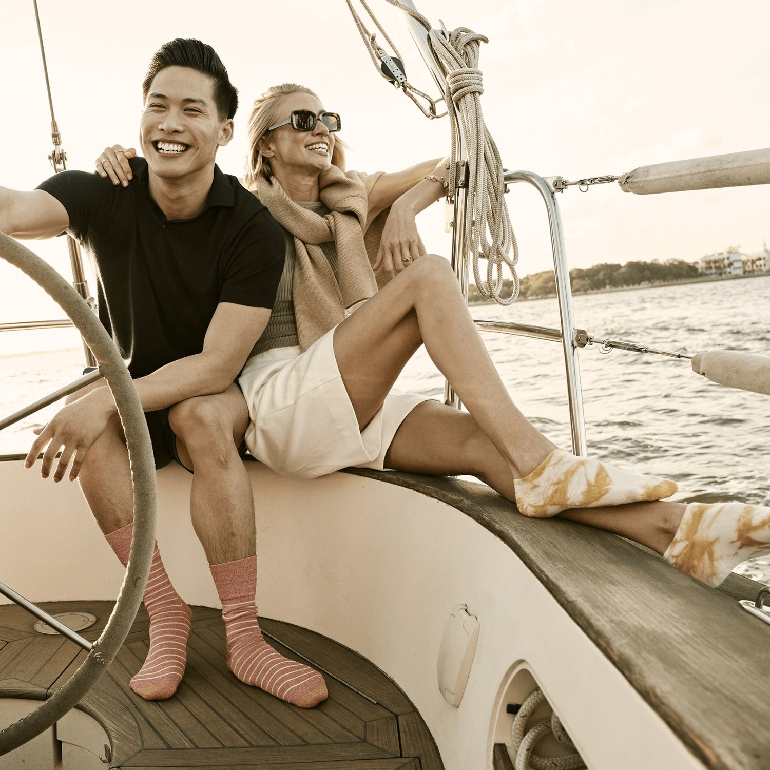 Un homme et une femme portent des chaussettes GOLDTOE sur un bateau.
