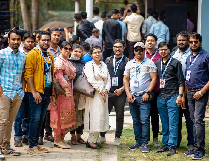 Un grupo de empleados de Bangladesh sonríen a la cámara en un acto de compromiso con los empleados e