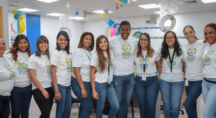 10 employés portent des chemises Gildan assorties et sourient lors d'un événement de bénévolat.