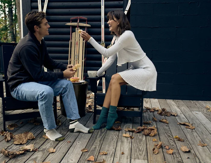 Une femme et un homme sont assis à l'extérieur et portent des chaussettes GOLTOE.