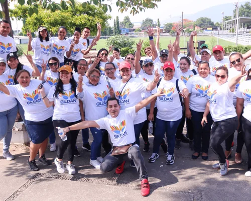 Des employés de Gildan sont à l'extérieur portant des t-shirts Gildan blancs et souriant à la caméra