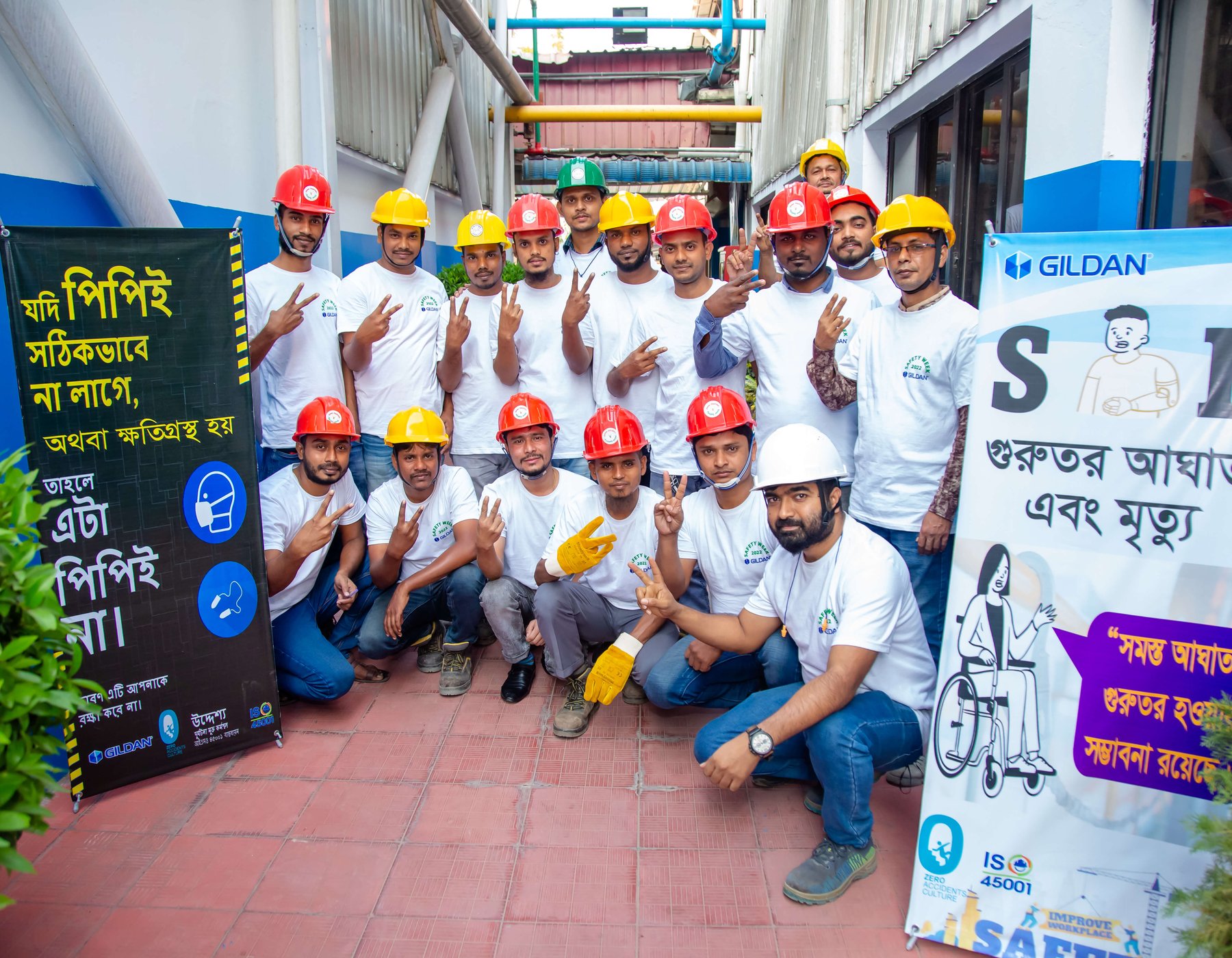 Un groupe d'employés portant des casques de sécurité sourit à la caméra.