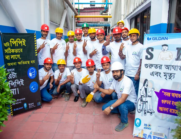 Un groupe d'employés portant des casques de sécurité sourit à la caméra.