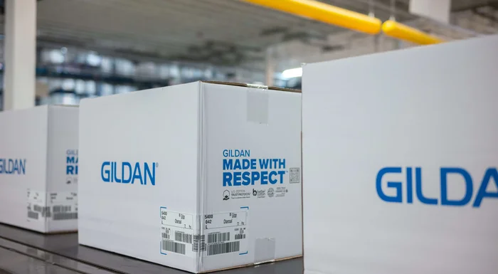 Les boîtes Gildan Made With Respect passent sur un tapis roulant.