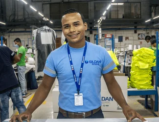 Un employé de Gildan porte un cordon et une chemise bleue de Gildan.