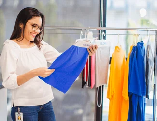 Dans la salle d'exposition, une femme regarde un morceau de tissu Gildan.