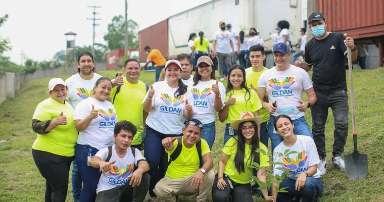 Les employés de Gildan du Honduras sourient avec les pouces levés tout en plantant des arbres.