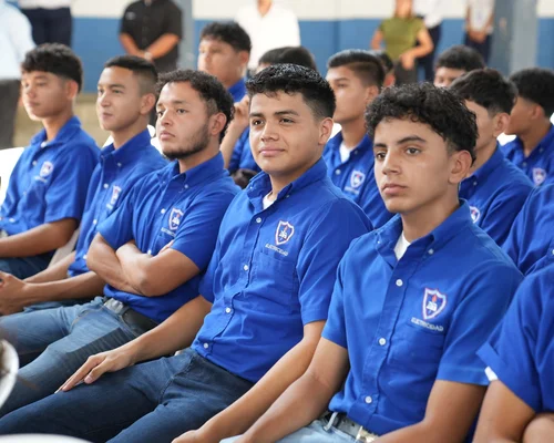 Children in Nicaragua are wearing school uniforms and smiling while holding school supplies.