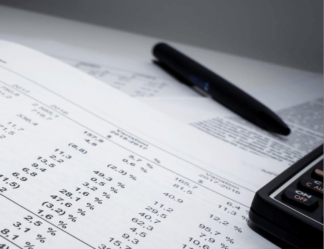 Three men and two women wearing Gildan™ on a beach looking at the camera.